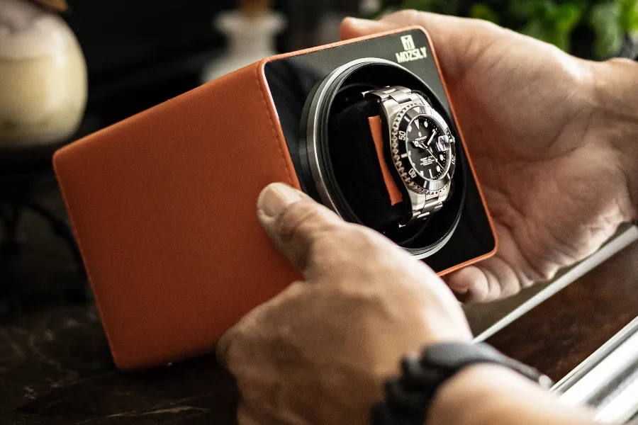 A hand holding the Mozsly watch winder